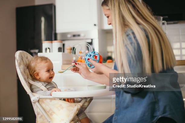 年輕的母親正在喂她的孩子 - freundschaftliche verbundenheit 個照片及圖片檔