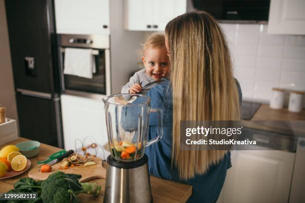 young mother is feeding her baby - alleinerzieherin stock pictures, royalty-free photos & images