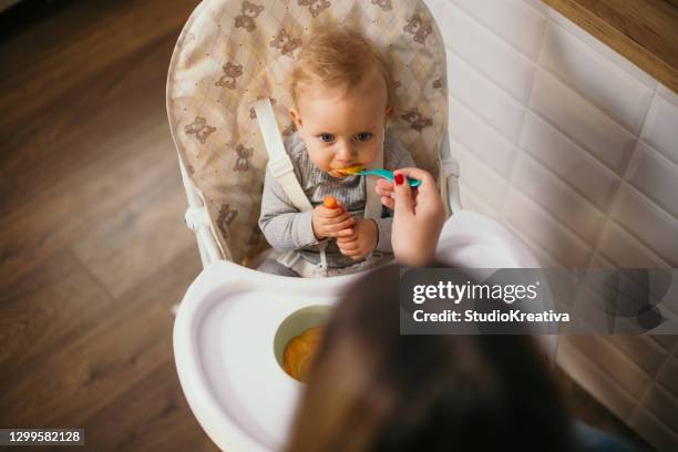 joven madre está alimentando a su bebé - alleinerzieherin fotografías e imágenes de stock