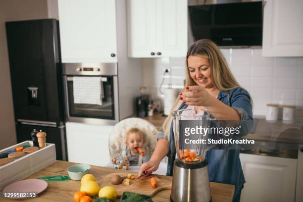 年輕的母親正在喂她的孩子 - freundschaftliche verbundenheit 個照片及圖片檔