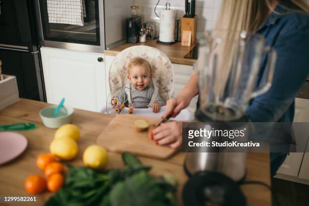 joven madre está alimentando a su bebé - ein elternteil fotografías e imágenes de stock