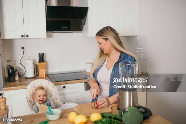 joven madre está alimentando a su bebé - alleinerzieherin fotografías e imágenes de stock