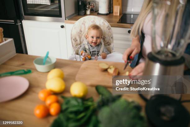 young mother is feeding her baby - alleinerzieherin stock pictures, royalty-free photos & images