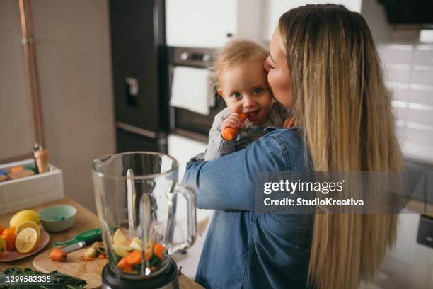 young mother is feeding her baby - alleinerzieherin stock pictures, royalty-free photos & images