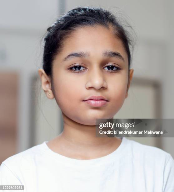 portrait of an indian/asian girl looking at camera with blank facial expression - 12 year old indian girl stock pictures, royalty-free photos & images