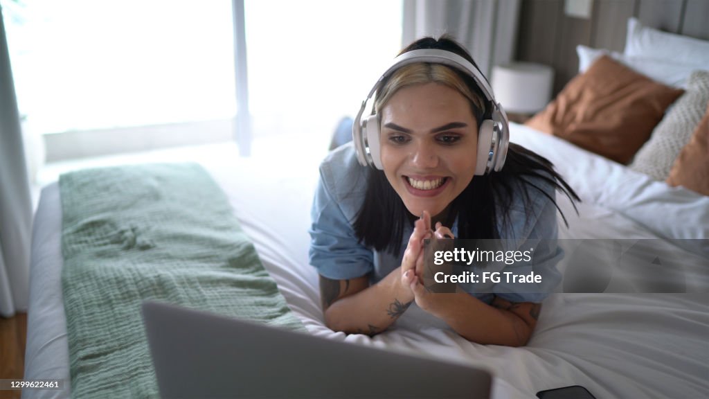 Transgender woman watching something on laptop (or on a video call) at home