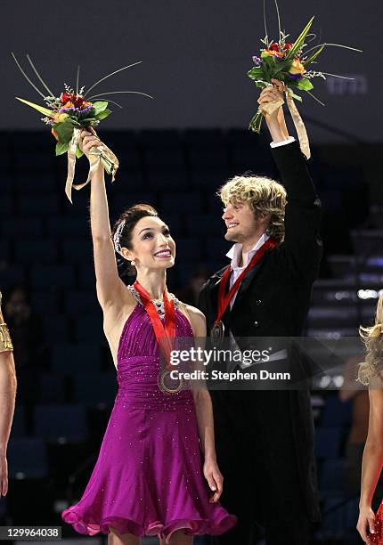 Meryl Davis and Charlie White wavew on the awards podium after winning the gold medal in the ice dance competition during Hilton HHonors Skate...