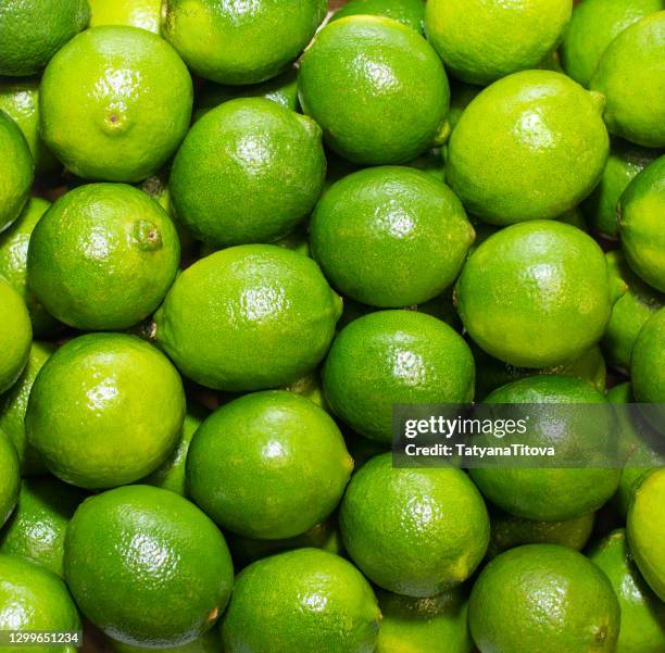 fresh ripe green limes as background, top view - lime stockfoto's en -beelden