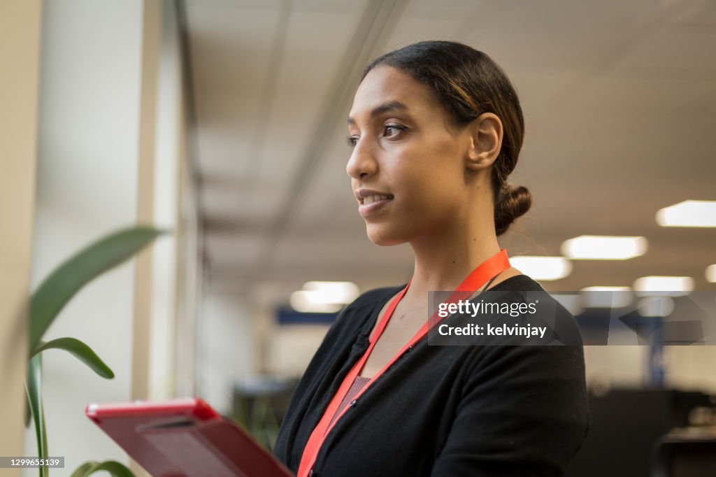 Young black woman using a digital tablet in an office