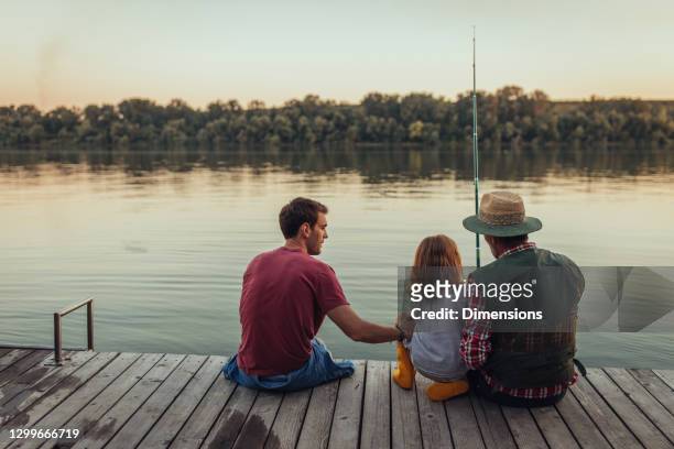 grandfather, father and little boy is fishing at the river - kids fishing stock pictures, royalty-free photos & images
