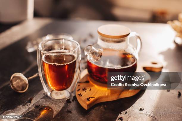 process brewing tea,tea ceremony,cup of freshly brewed black tea,warm soft light, darker background. - black cup saucer stock pictures, royalty-free photos & images