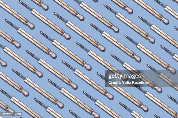 repeated thermometers on the blue background - mercury thermometer stock pictures, royalty-free photos & images