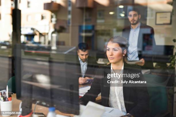 personas que trabajan en una oficina vista a través de la ventana en una empresa - couple at bank fotografías e imágenes de stock