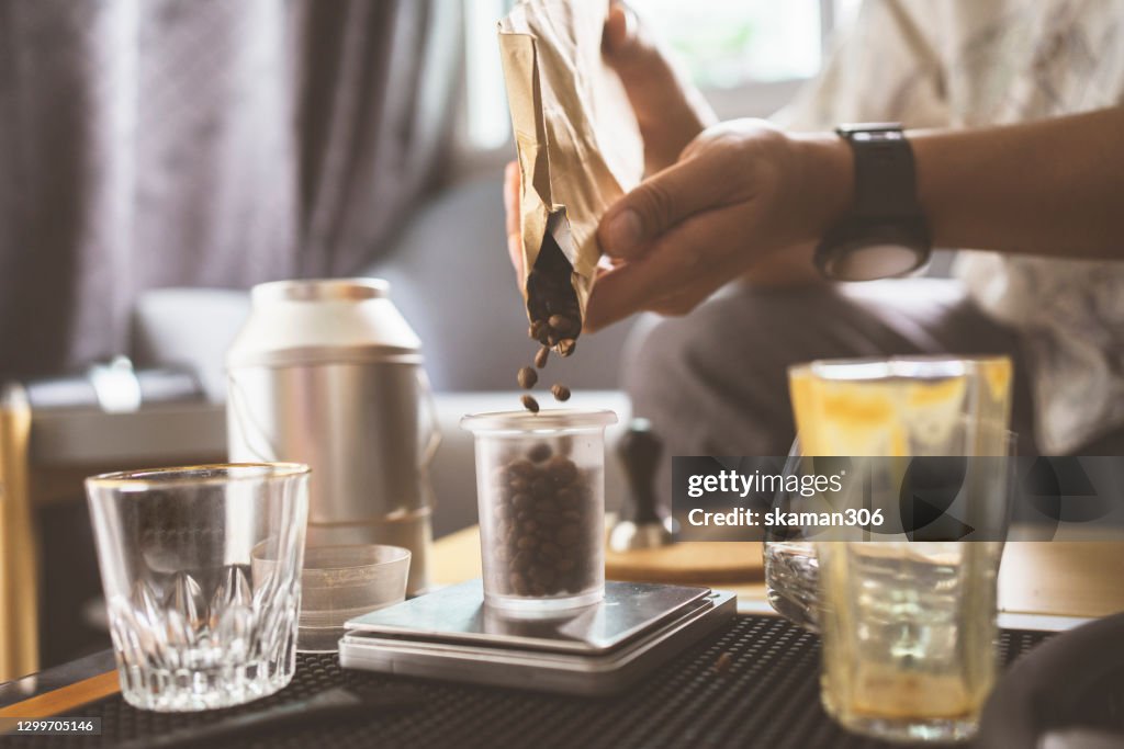 Wide agle of solo asian young man adult grinder coffee bean for brewing hot espresso daily life at home