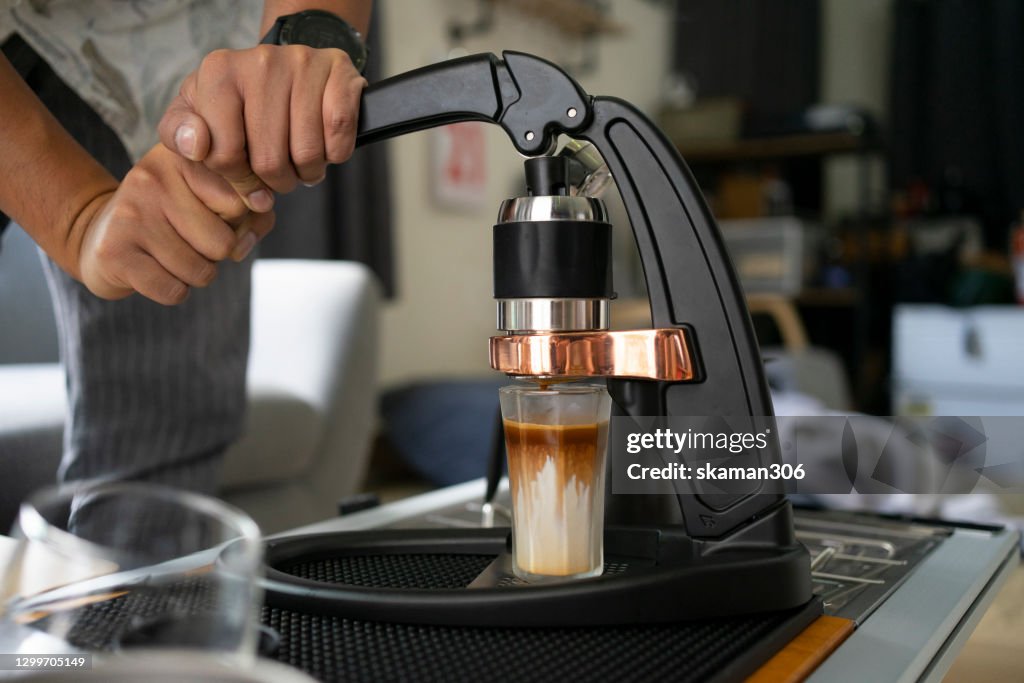 Wide agle of solo asian young man adult grinder coffee bean for brewing hot espresso daily life at home
