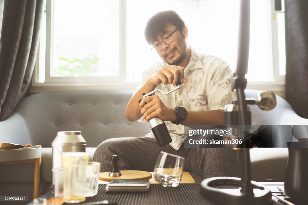 Wide agle of solo asian young man adult grinder coffee bean for brewing hot espresso daily life at home