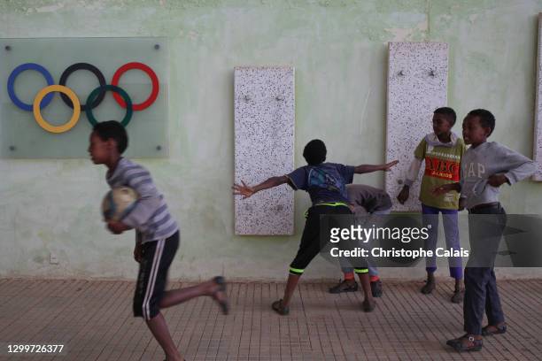 Enfants jouant au football devant le symbole des Jeux Olympique dans une rue d’ Asmara, capitale de l’Erythrée.