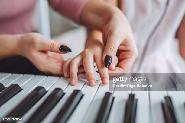 little girl have music piano lesson with her female teacher at home - pianist imagens e fotografias de stock