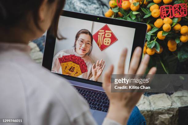 asian woman using laptop to video call her family/friend/lover during chinese new year - chinese symbols stock pictures, royalty-free photos & images