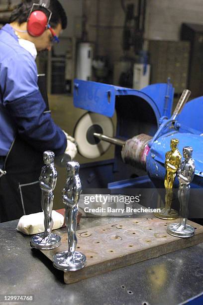 Jose Irizarry buffs an Oscar statuette at R.S. Owens and Company in Chicago