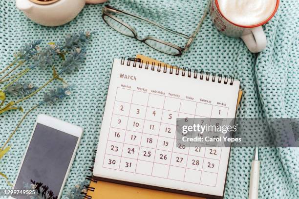 march calendar  in feminine workspace with lavender flowers, coffee , eyeglasses and pen - equinox stockfoto's en -beelden