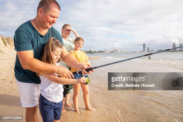 family spends time at the beach playing together on the sand - fishing australia stock pictures, royalty-free photos & images