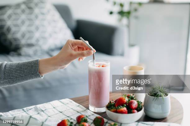 cropped shot of young woman drinking a glass of fresh and healthy strawberry smoothie with reusable metal straw. healthy eating and healthy lifestyle - metal straw stock pictures, royalty-free photos & images