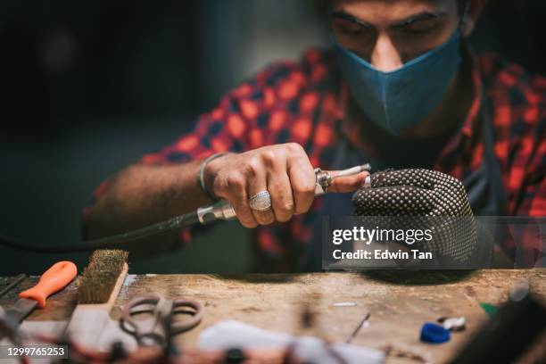 medio oriente masculino estudiante pulir joyas en la mesa de trabajo de la universidad - estudiando flexo fotografías e imágenes de stock