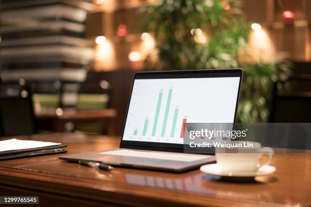 laptops and coffee cups, pens and documents on the desk, no one at the desk - table numbers stock-fotos und bilder