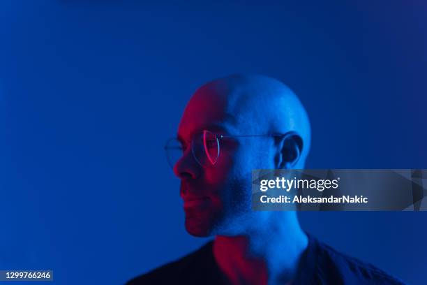 studio portrait of a young man - neon light stock pictures, royalty-free photos & images