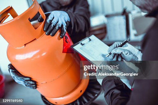 Liquified Gas Storage Workers Writing Down Cylinder Serial Number Liquified Gas Storage Workers Writing Down Cylinder Serial Number
