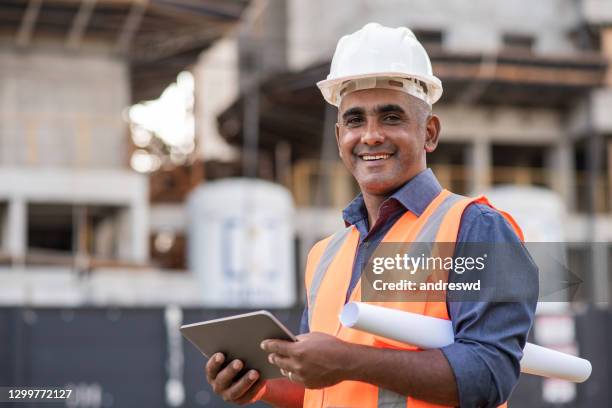 ingénieur sur le chantier, utilisant la tablette numérique - ouvrier du bâtiment photos et images de collection