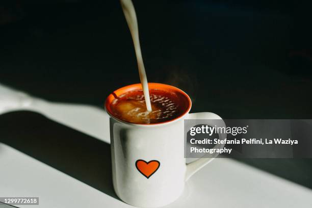 dairy free milk pouring in a hot tea mug - milk tea cup stock pictures, royalty-free photos & images