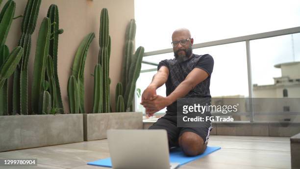 mature man exercising at home while watching online class - exercise computer stock pictures, royalty-free photos & images