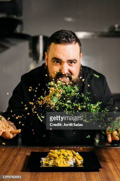 portrait of a chef throwing parsley and peanuts - chopping vegetables stock pictures, royalty-free photos & images