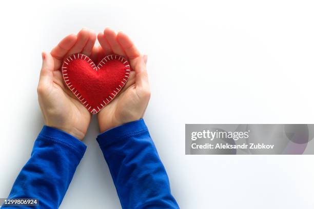 a girl or woman holds a red handmade heart on a white background. the concept of valentine's day, health and medicine. - true peoples celebration day one stock pictures, royalty-free photos & images