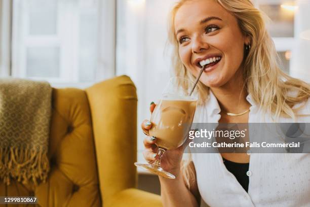 smiling woman sips a cold drink with a metal straw - taste test stock pictures, royalty-free photos & images
