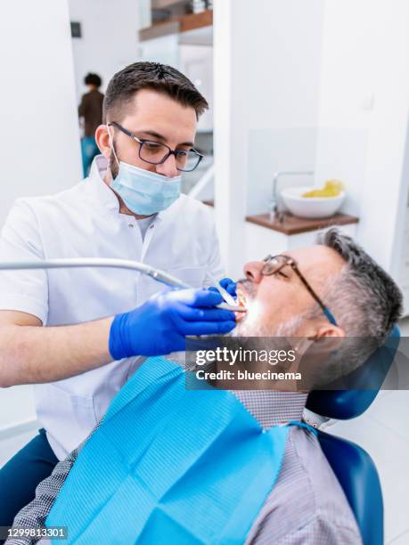 mature man at the dentist - dental cleaning stock pictures, royalty-free photos & images