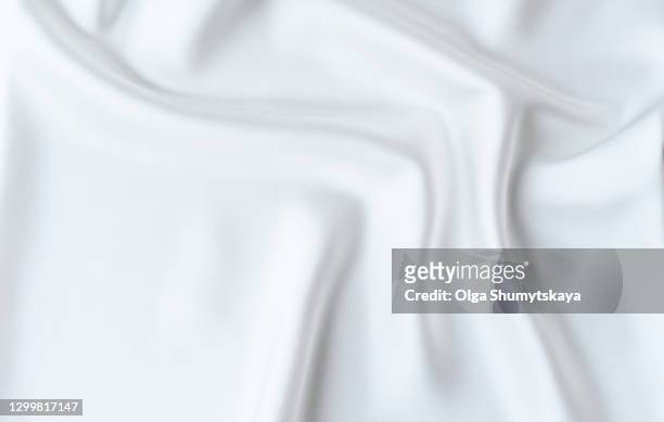 the background is made of light folds of delicate flowing white silk. - zijde stockfoto's en -beelden