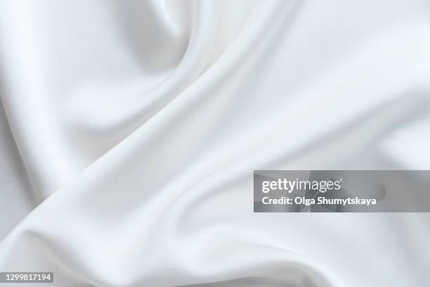 the background is made of light folds of delicate flowing white silk. - seda imagens e fotografias de stock