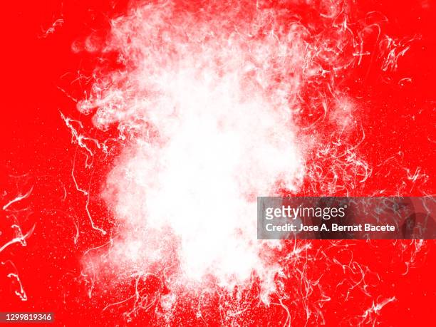 explosion of a cloud of particles of powder and smoke of white color on a red background. - atoombom stockfoto's en -beelden