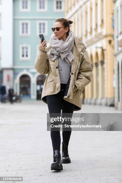 Fashion designer Eva Lutz wearing a beige jacket by Balenciaga, black pants by Balenciaga, a grey knitted pullover, a grey scarf by Pur schoen, brown...