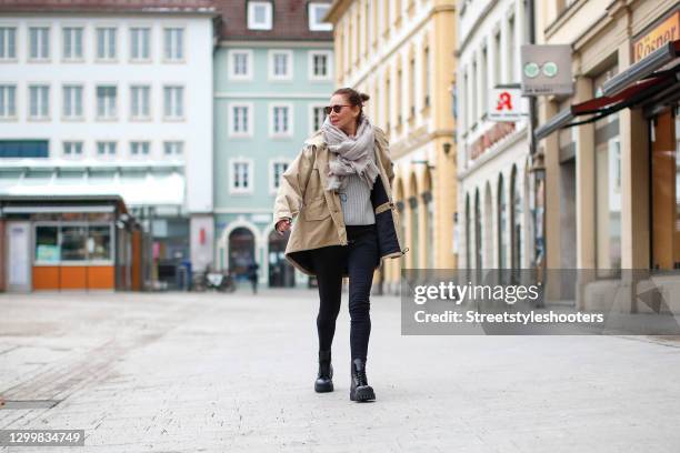 Fashion designer Eva Lutz wearing a beige jacket by Balenciaga, black pants by Balenciaga, a grey knitted pullover, a grey scarf by Pur schoen, brown...