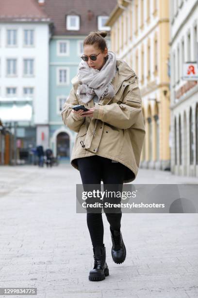 Fashion designer Eva Lutz wearing a beige jacket by Balenciaga, black pants by Balenciaga, a grey knitted pullover, a grey scarf by Pur schoen, brown...