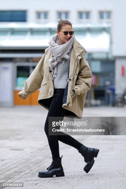 Fashion designer Eva Lutz wearing a beige jacket by Balenciaga, black pants by Balenciaga, a grey knitted pullover, a grey scarf by Pur schoen, brown...