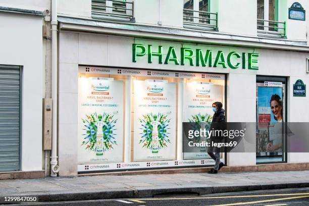 pharmacy with a people wearing a mask during pandemic covid-19 - store window stock pictures, royalty-free photos & images