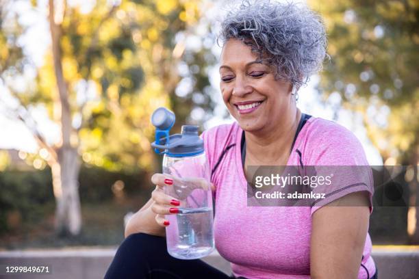 mujer negra hidratante después del entrenamiento - agua dulce fotografías e imágenes de stock