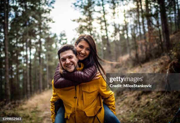 young couple have a fun on their autumn adventure - park couple piggyback stock pictures, royalty-free photos & images