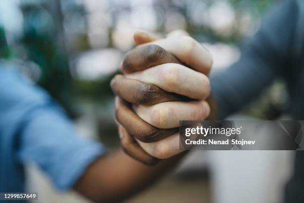 disparo de estudio antirracista de un grupo irreconocible de personas que se sostienen de la mano - respect fotografías e imágenes de stock