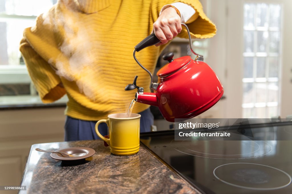 Frau bereitet einen Tee zu